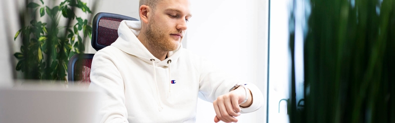 Mitarbeiter der Werbeagentur dreibein sieht auf die Uhr