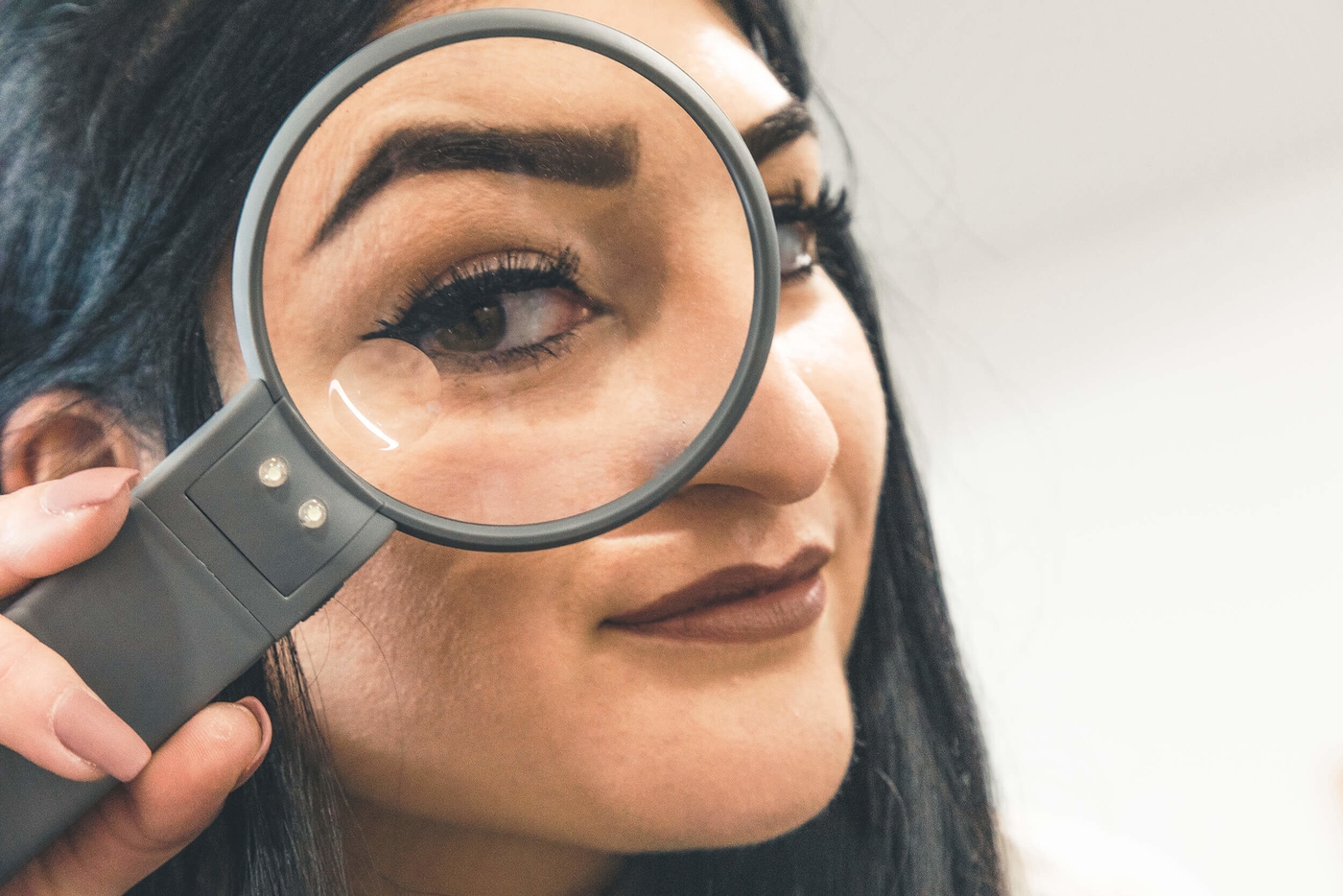 Anna hält die Lupe vor Ihr Auge