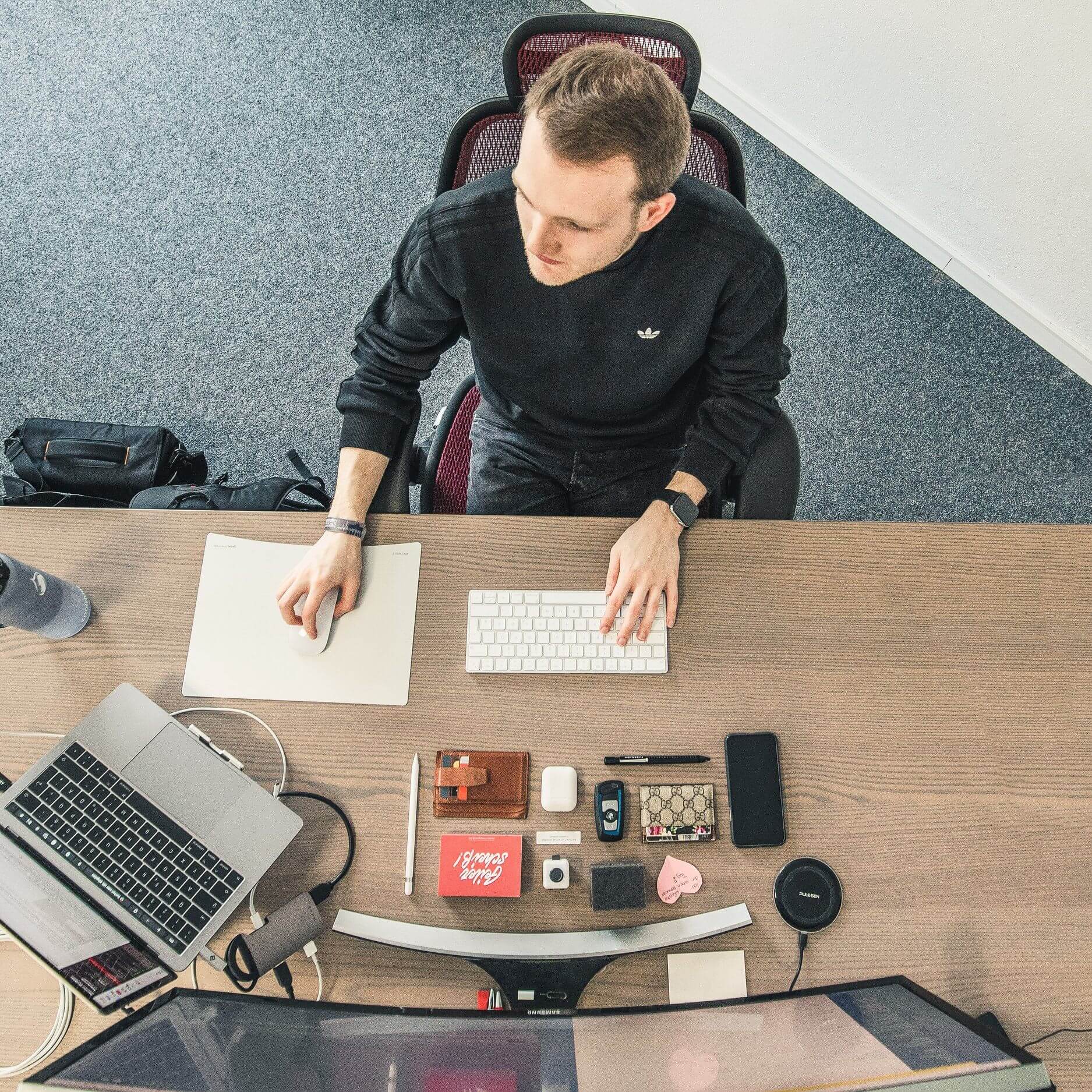 Eine Person sitzt an sehr organisiertem Schreibtisch