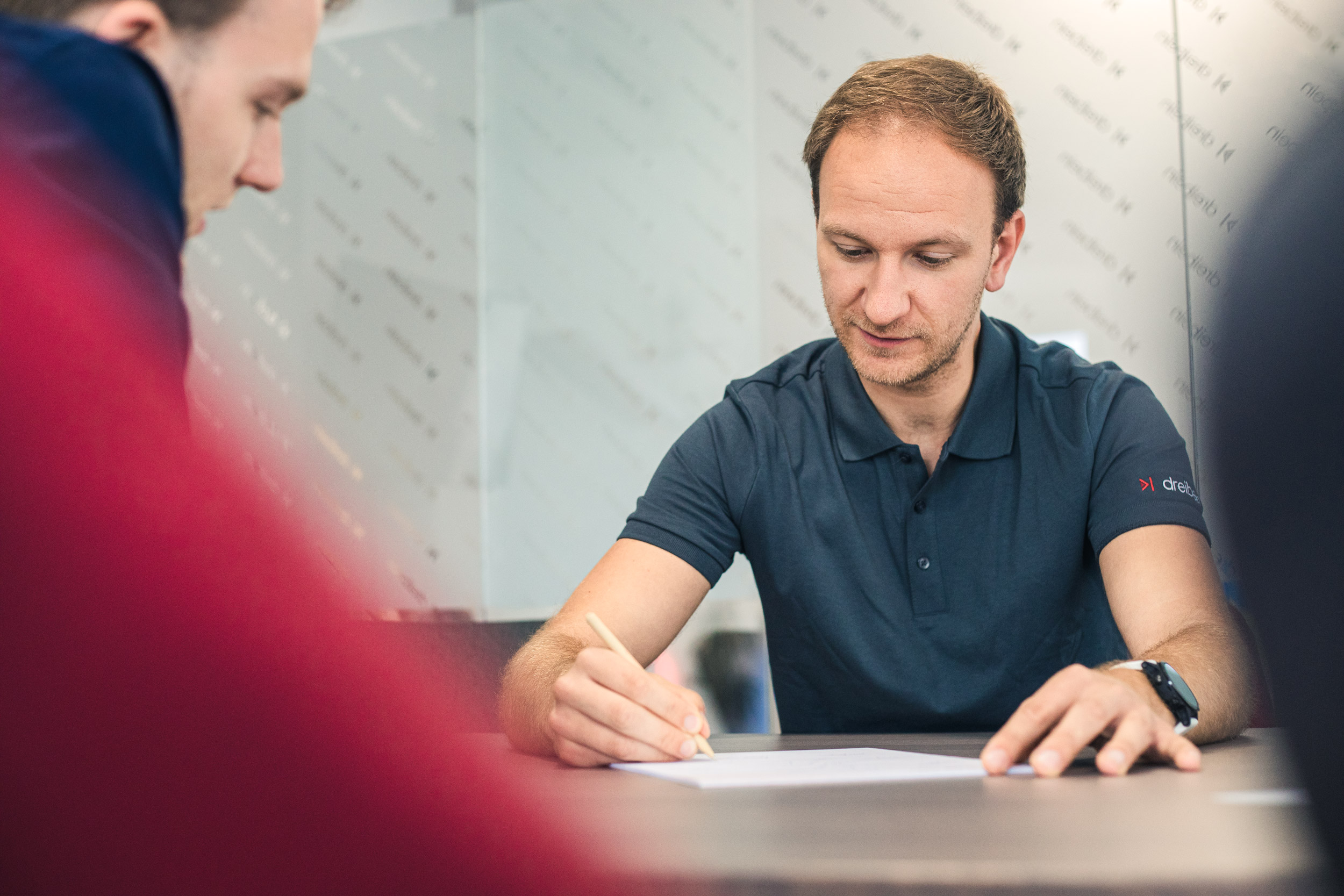 Sebastian erklärt an der Tafel die Vor- und Nachteile der unterschiedlichen Marketing Kanäle